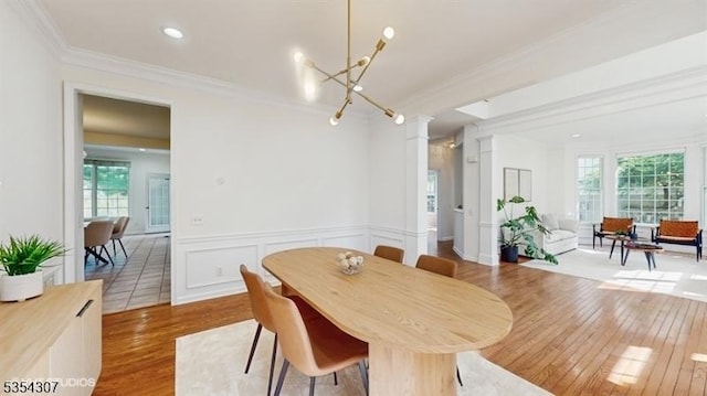 dining space featuring crown molding, a healthy amount of sunlight, and wood finished floors
