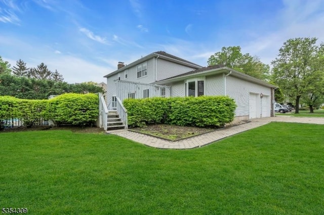 view of side of home featuring a garage, a yard, and driveway