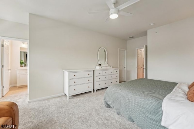 bedroom with light carpet, ensuite bath, a ceiling fan, baseboards, and visible vents