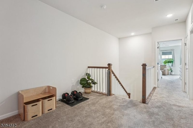 hallway featuring carpet floors, recessed lighting, baseboards, and an upstairs landing