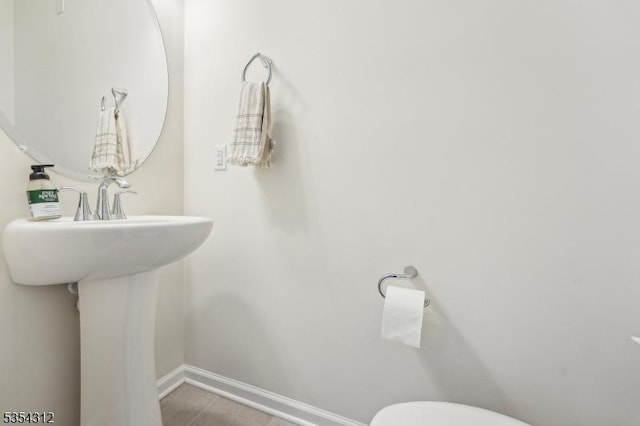 bathroom with baseboards and toilet