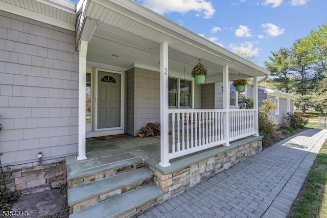 view of exterior entry featuring covered porch