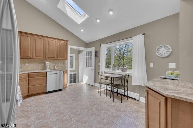 kitchen featuring backsplash, a skylight, light stone countertops, light tile patterned floors, and stainless steel appliances
