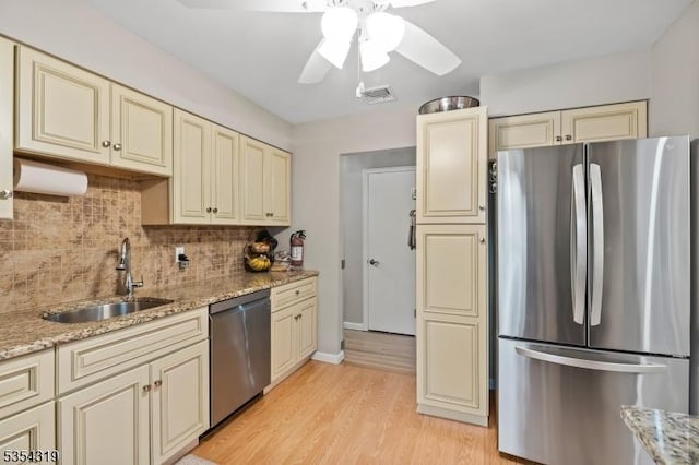 kitchen featuring a sink, cream cabinets, stainless steel appliances, and visible vents