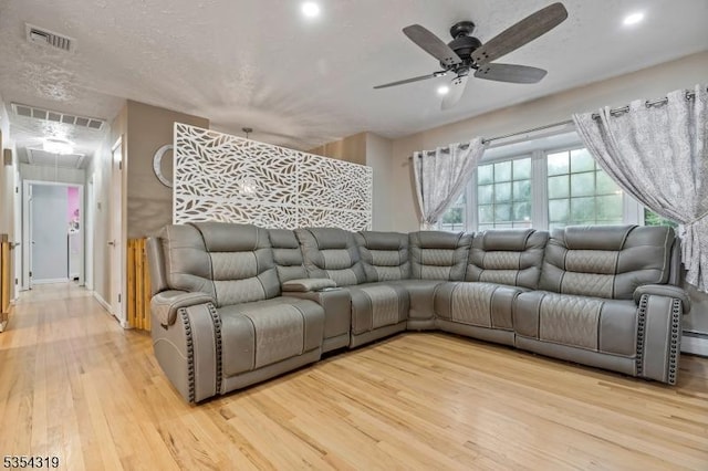 living area with ceiling fan, attic access, light wood-type flooring, and visible vents