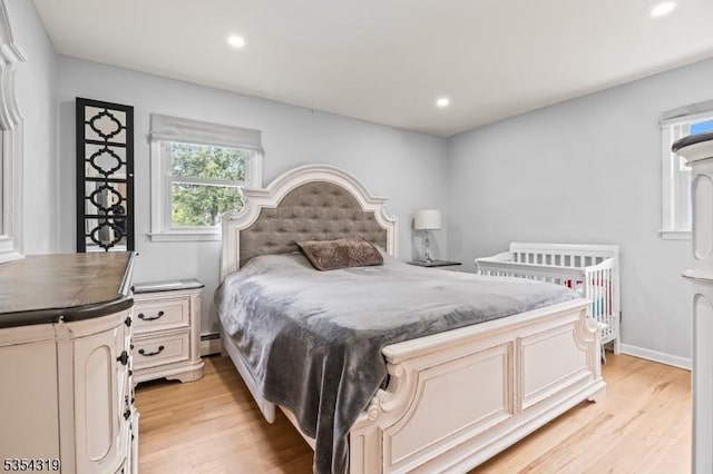 bedroom with recessed lighting, light wood finished floors, and a baseboard radiator