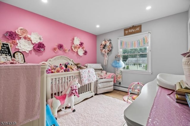bedroom featuring recessed lighting, a baseboard heating unit, and wood finished floors