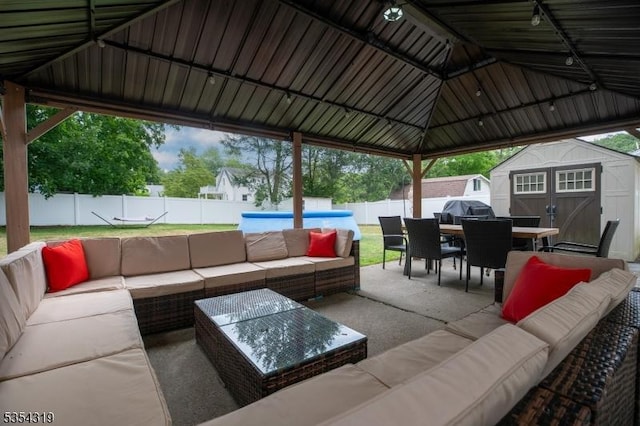 view of patio / terrace featuring a fenced backyard, outdoor dining area, an outdoor living space, and a shed