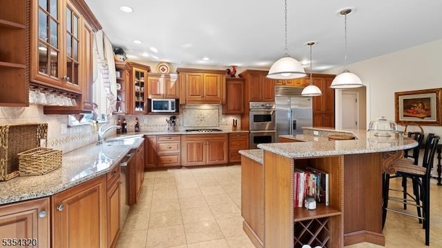 37 Gregory Ave, West Orange Twp, NJ 07052 - kitchen with appliances with stainless steel finishes, a breakfast bar area, brown cabinets, a sink, and backsplash