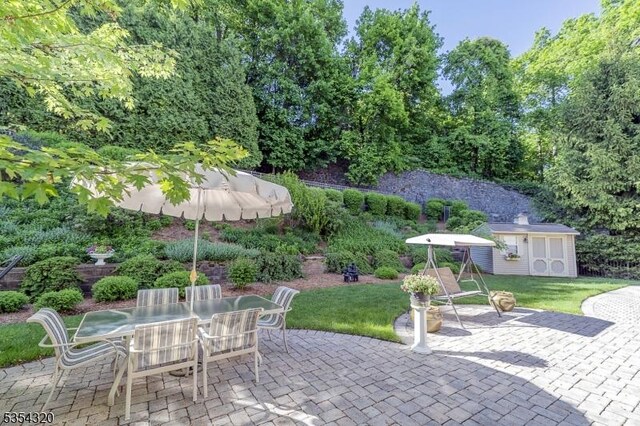 37 Gregory Ave, West Orange Twp, NJ 07052 - view of patio featuring an outbuilding, outdoor dining space, and a storage shed