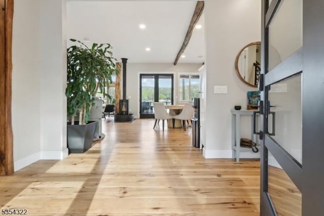 hallway with recessed lighting, baseboards, beamed ceiling, and light wood finished floors