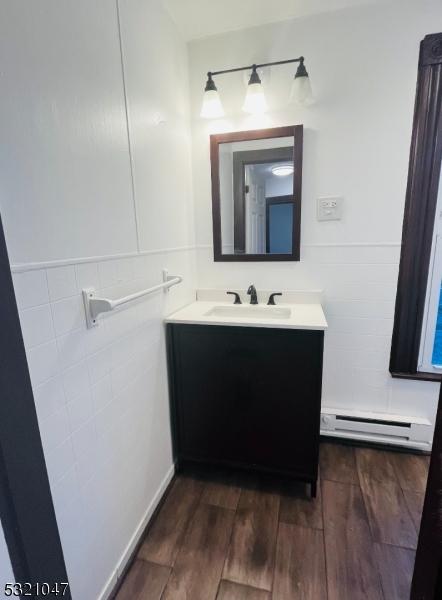 bathroom featuring vanity, baseboard heating, and wood finished floors