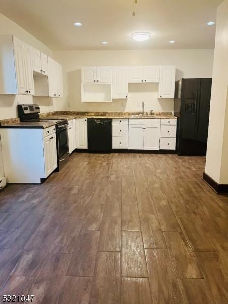 kitchen with a sink, dark wood finished floors, black appliances, and white cabinets