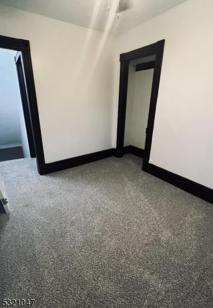 spare room featuring baseboards, carpet, and a ceiling fan