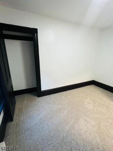 empty room featuring carpet floors and baseboards