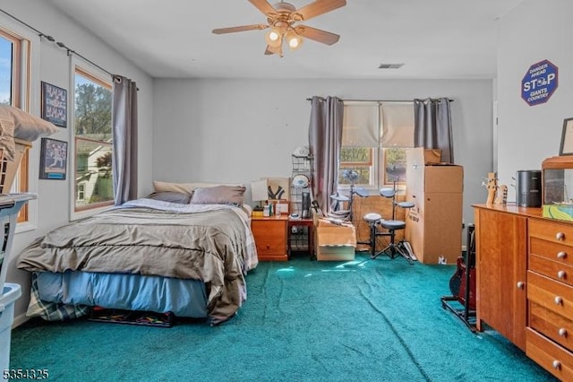 bedroom with ceiling fan, visible vents, and carpet