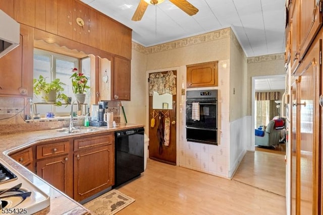 kitchen featuring plenty of natural light, a sink, a warming drawer, and black appliances