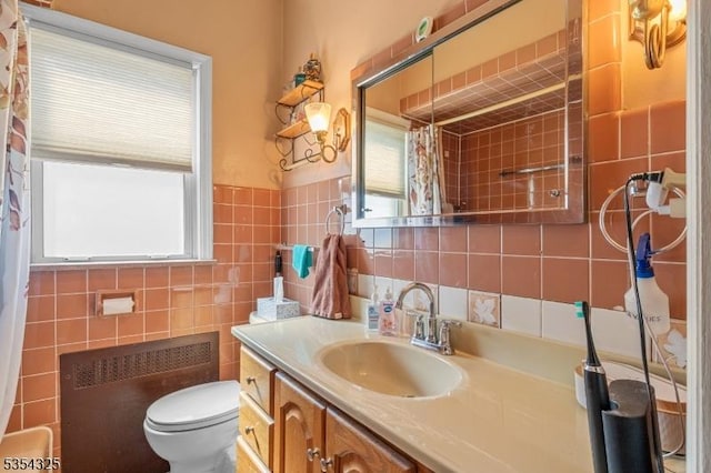 bathroom featuring vanity, toilet, tile walls, a shower with shower curtain, and radiator heating unit