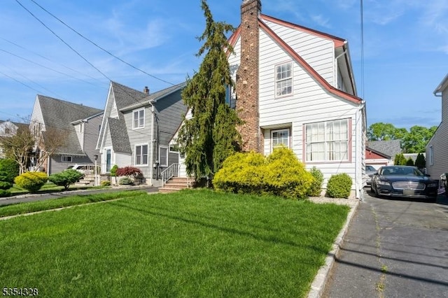 view of front facade with a chimney and a front yard