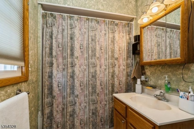 full bathroom with vanity, wallpapered walls, and curtained shower