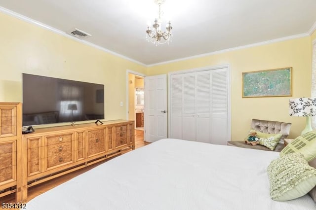 bedroom featuring visible vents, ornamental molding, a closet, wood finished floors, and a notable chandelier