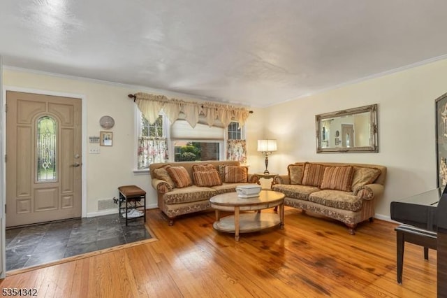 living area featuring crown molding, baseboards, and hardwood / wood-style floors