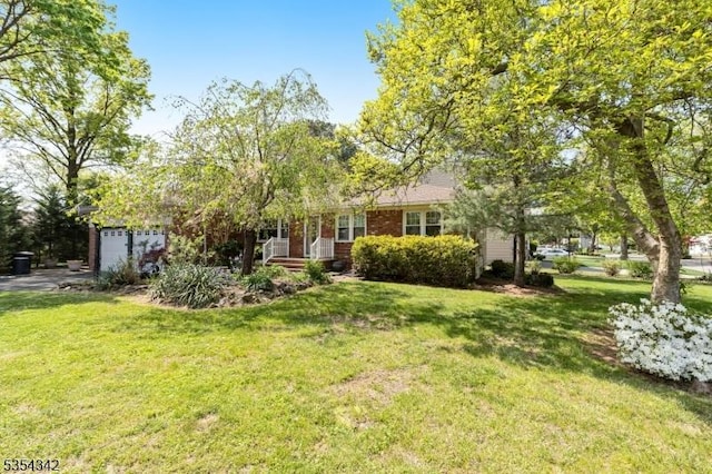 view of front of house featuring an attached garage, a front lawn, and brick siding