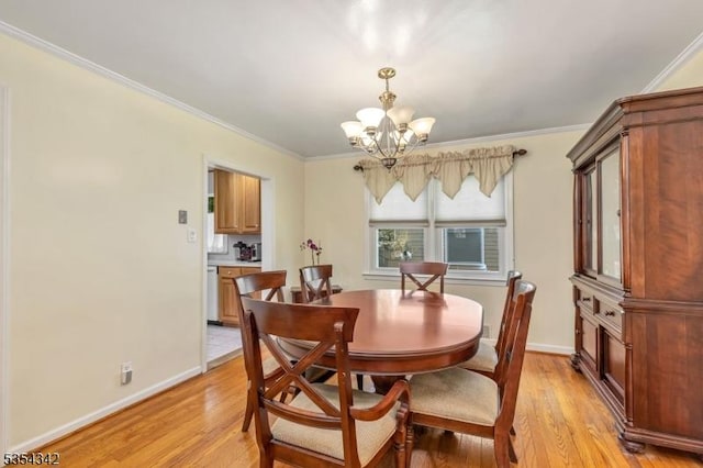 dining room with an inviting chandelier, baseboards, crown molding, and light wood-type flooring