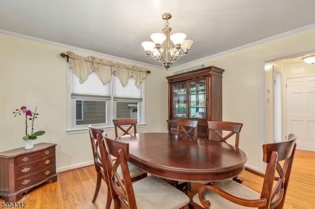 dining room with crown molding, baseboards, an inviting chandelier, and light wood finished floors