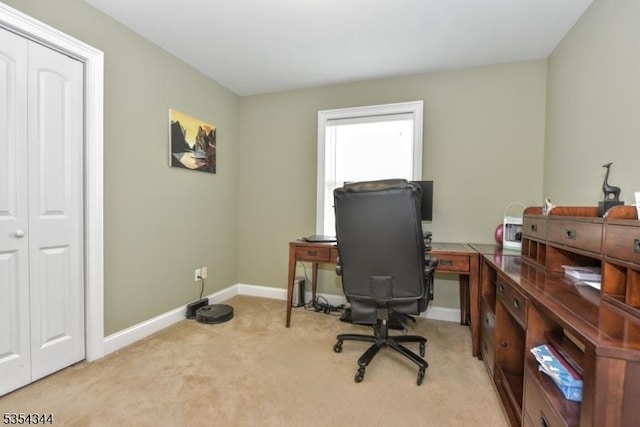 office featuring baseboards and light carpet