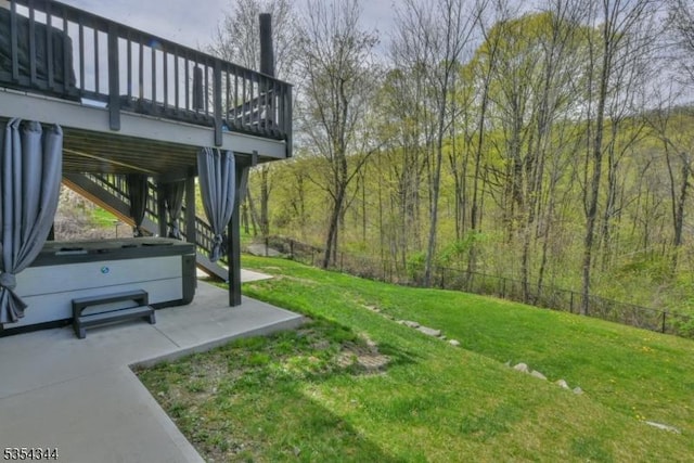 view of yard featuring fence, stairs, a hot tub, a deck, and a patio