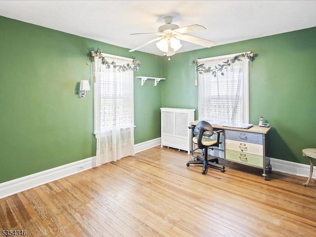 office area with baseboards, a ceiling fan, and wood finished floors