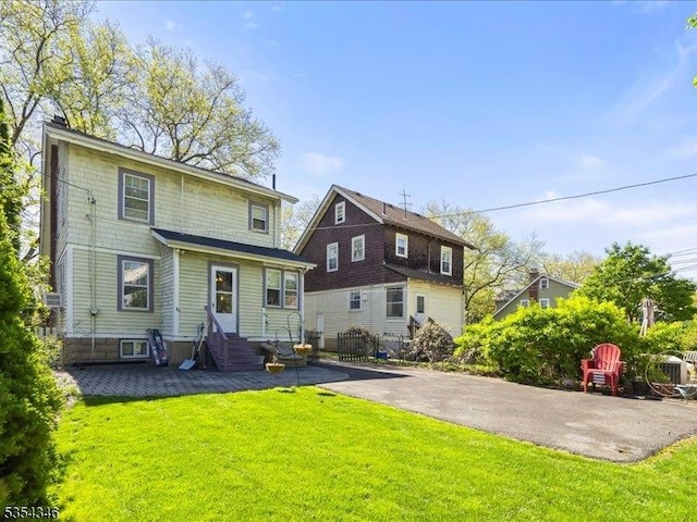 back of house featuring a yard and entry steps