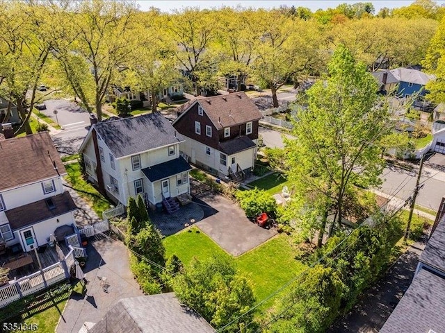 drone / aerial view featuring a wooded view and a residential view