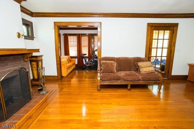 living area with crown molding, wood finished floors, and a fireplace