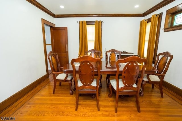 dining area featuring baseboards, ornamental molding, and light wood-type flooring