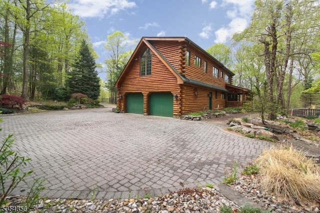 31 Kent Rd, Hampton Twp, NJ 07860 - view of home's exterior with log siding, an attached garage, and decorative driveway