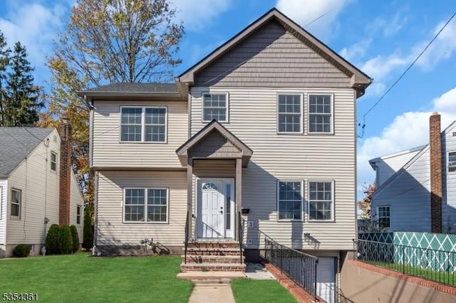 view of front facade featuring fence, an attached garage, and a front lawn
