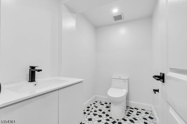 bathroom with vanity, toilet, recessed lighting, baseboards, and visible vents