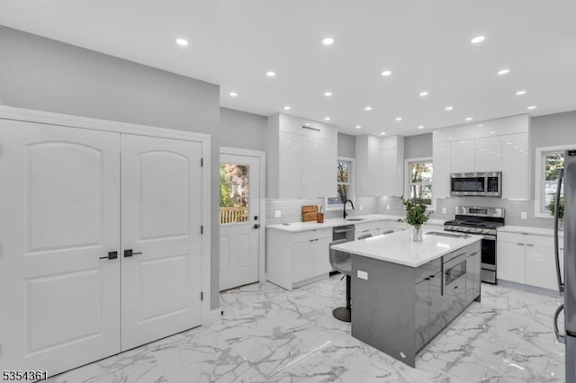kitchen featuring decorative backsplash, appliances with stainless steel finishes, modern cabinets, and white cabinets