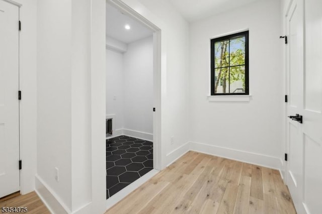 clothes washing area with baseboards, recessed lighting, and light wood-style flooring