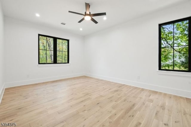 empty room with light wood-type flooring, recessed lighting, and baseboards