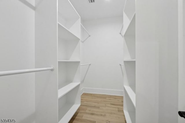walk in closet featuring wood finished floors