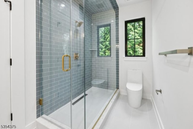 bathroom with tile patterned floors, baseboards, a shower stall, and toilet