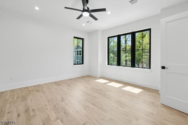 spare room featuring light wood-style floors, baseboards, recessed lighting, and visible vents