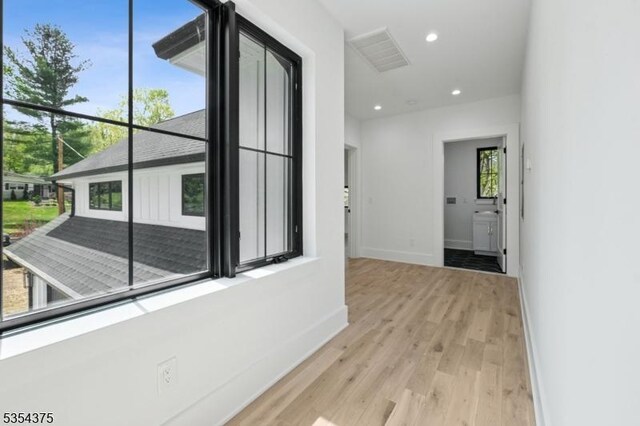 hallway with baseboards, recessed lighting, wood finished floors, and visible vents