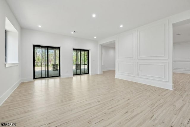 unfurnished living room with recessed lighting and light wood-style flooring