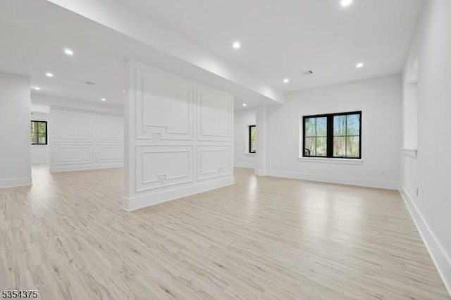 unfurnished living room featuring baseboards, recessed lighting, and light wood-style flooring