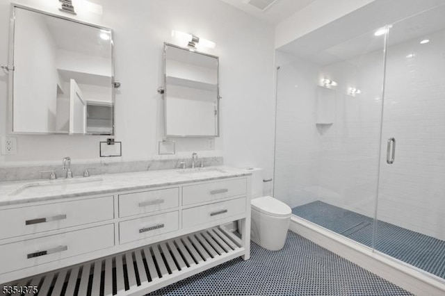 bathroom featuring double vanity, a sink, toilet, and a shower stall