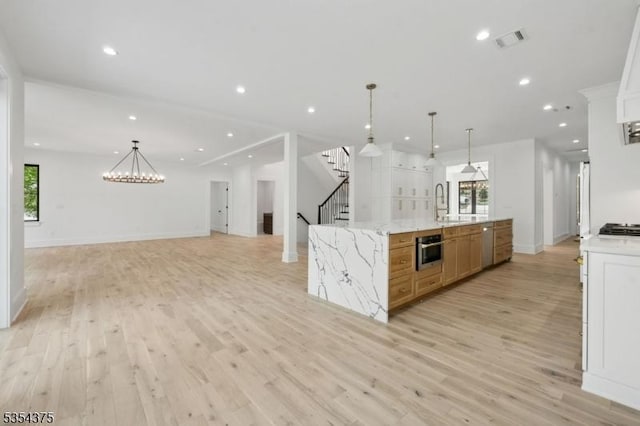 kitchen with gas stovetop, light wood finished floors, open floor plan, and visible vents